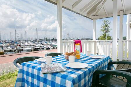 Gedekte tafel onder een veranda van een vakantiehuis op vakantiepark Roompot Cape Helius