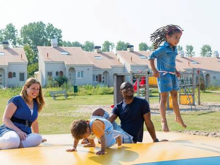 kinderen springen op de airtrampoline in een speeltuin op vakantiepark Roompot Duinresort Dunimar