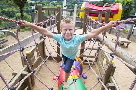 Kind speelt in een speeltuin op vakantiepark Roompot Eifelpark Kronenburger See