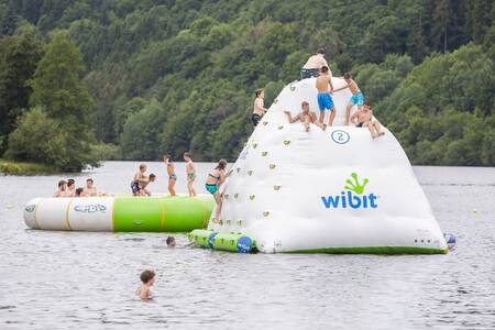 Kinderen spelen op een speelkussen in het stuwmeer naast Roompot Eifelpark Kronenburger See