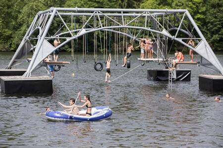 Kinderen spelen in het water van het stuwmeer naast Roompot Eifelpark Kronenburger See