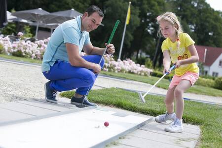 Gezin aan het golfen op de minigolfbaan van vakantiepark Roompot Ferienresort Bad Bentheim