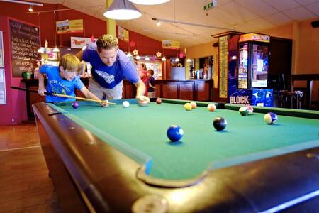 Vader en zoon aan het poolen in het café op Roompot Ferienresort Cochem