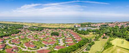 Luchtfoto van vakantiepark Roompot Hof Domburg met de zee aan de horizon
