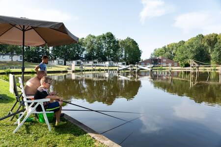 Mensen aan het vissen in het water op vakantiepark Roompot Hunzepark