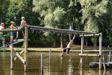 Kinderen op een waterspeeltoestel van hout op vakantiepark Roompot Hunzepark