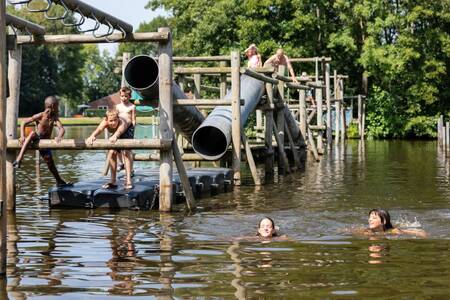 Kinderen spelen in het water op een speeltoestel op vakantiepark Roompot Hunzepark