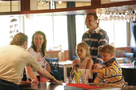 Gezin aan de bar in een restaurant op vakantiepark Roompot Kustpark Texel