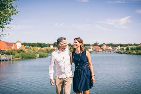 Man en vrouw voor het meer op vakantiepark Roompot Noordzee Résidence Cadzand-Bad