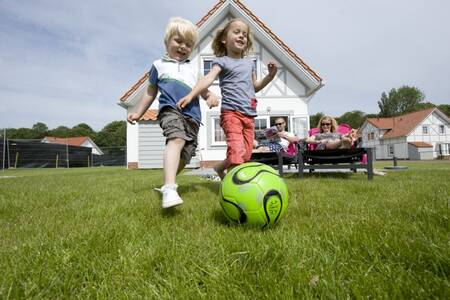 Kinderen spelen in de tuin van een vakantiehuis op Roompot Noordzee Résidence Cadzand-Bad