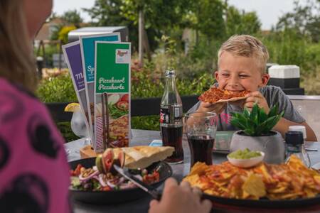 Gezin dineert op het terras van een restaurant op Roompot Noordzee Résidence De Banjaard