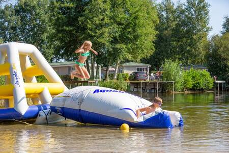 Kinderen op een speeltoestel in het meer op Roompot Recreatiepark de Tolplas