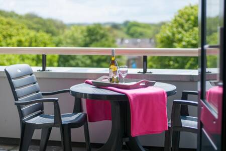 Tafeltje en stoelen op het balkon van een appartement op Roompot Résidence Wijngaerde