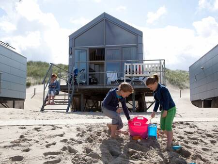 Kinderen spelen in het zand voor een Beach House op Roompot Strandhuisjes Julianadorp