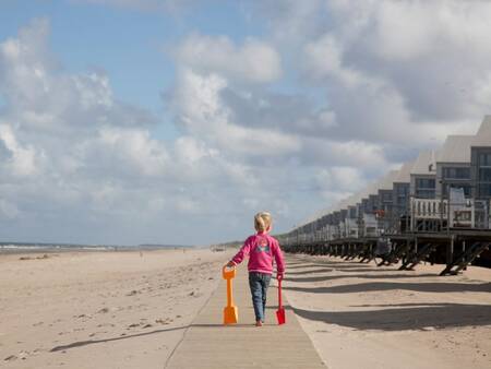 Kind wandelt op het strand voor strandhuizen op Roompot Strandhuisjes Julianadorp