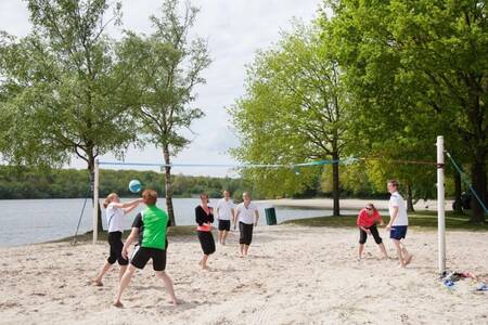 Mensen volleyballen op het strand vlakbij Roompot Villaparc Schoonhovenseland