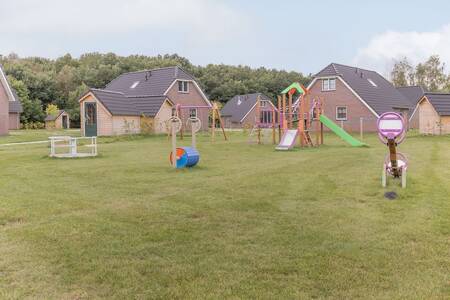 Een speeltuin tussen vakantiehuizen op het kleinschalige Roompot Villaparc Schoonhovenseland