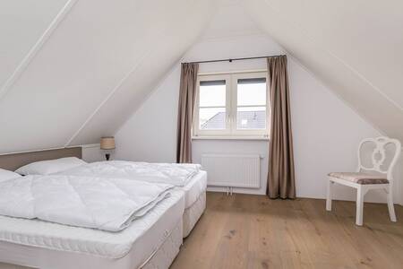 Slaapkamer met tweepersoonsbed in een vakantiehuis op Roompot Villaparc Schoonhovenseland