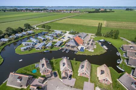Luchtfoto van vakantiehuizen aan het water op vakantiepark Roompot Waterpark Terkaple