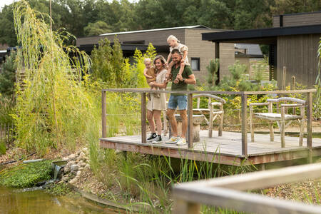 Gezin op een steiger van een vakantiehuis op vakantiepark Soof Retreats Soof Heuvelrug