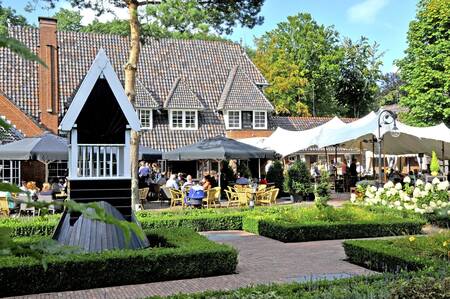 Mensen op het terras van het restaurant op vakantiepark Topparken Landgoed de Scheleberg