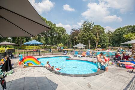 Kinderen in het peuterbadje met glijbaan op vakantiepark Topparken Landgoed de Scheleberg