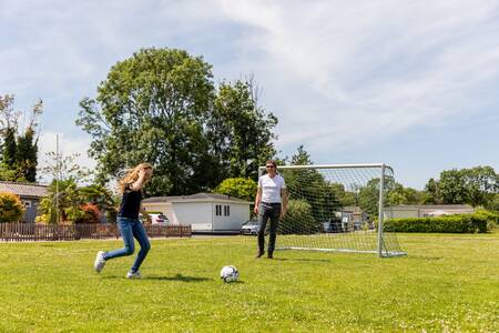 Mensen voetballen op het speelveld op vakantiepark Topparken Parc de IJsselhoeve