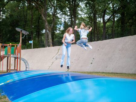 Kinderen springen op de airtrampoline in de speeltuin van Topparken Recreatiepark de Wielerbaan