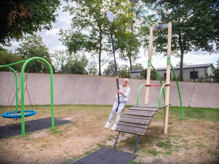 Meisje op de kabelbaan in de speeltuin op Topparken Recreatiepark de Wielerbaan