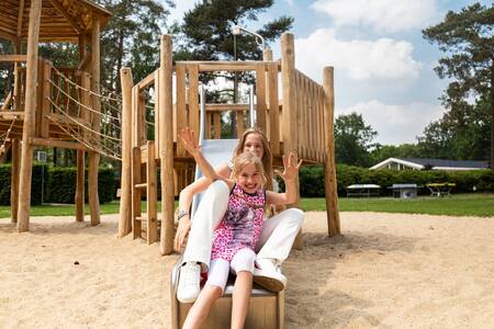 Kinderen op de glijbaan in een speeltuin op vakantiepark Topparken Recreatiepark 't Gelloo