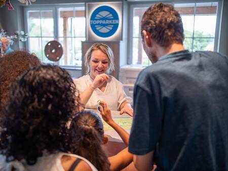 Gezin neemt sleutel in ontvangst bij de receptie van vakantiepark Topparken Residence Lichtenvoorde