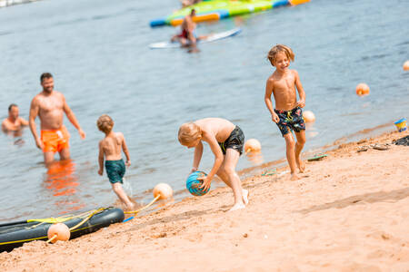 Mensen op het strand en in het water van het Leukermeer op vakantiepark Leukermeer