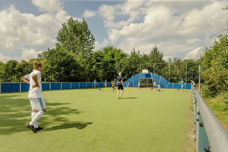 Kinderen aan het voetballen op het all-weather sportveld van vakantiepark Mölke