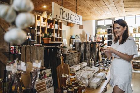 Vrouw aan het winkelen in de streekwinkel van vakantiepark Mölke