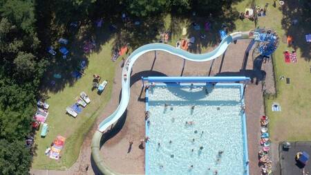 Luchtfoto van mensen in het buitenbad en grote glijbaan op vakantiepark Witterzomer