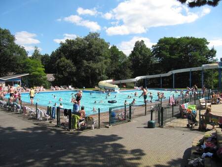 Mensen in het buitenbad met grote glijbaan op vakantiepark Witterzomer