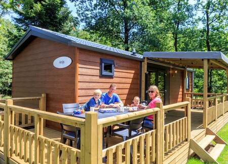 Gezin op het terras van een chalet op Veluwecamping De Pampel