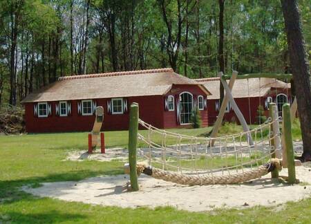 Vakantiehuizen type "Boerderij Grand" naast een kleine speeltuin op Veluwecamping De Pampel