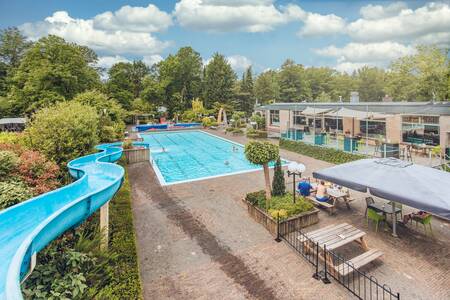 Het buitenbad met lange blauwe glijbaan van Veluwepark de Bosgraaf
